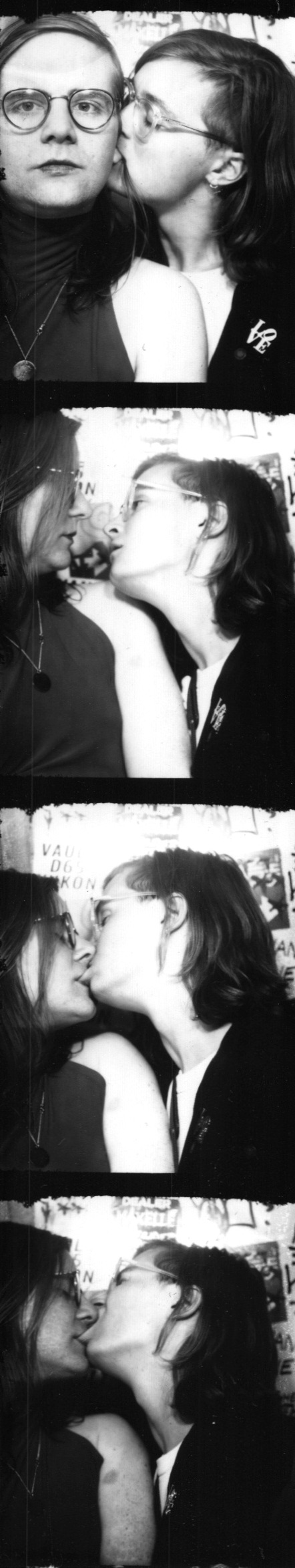 Black-and-white four-frame photobooth strip of two people kissing.